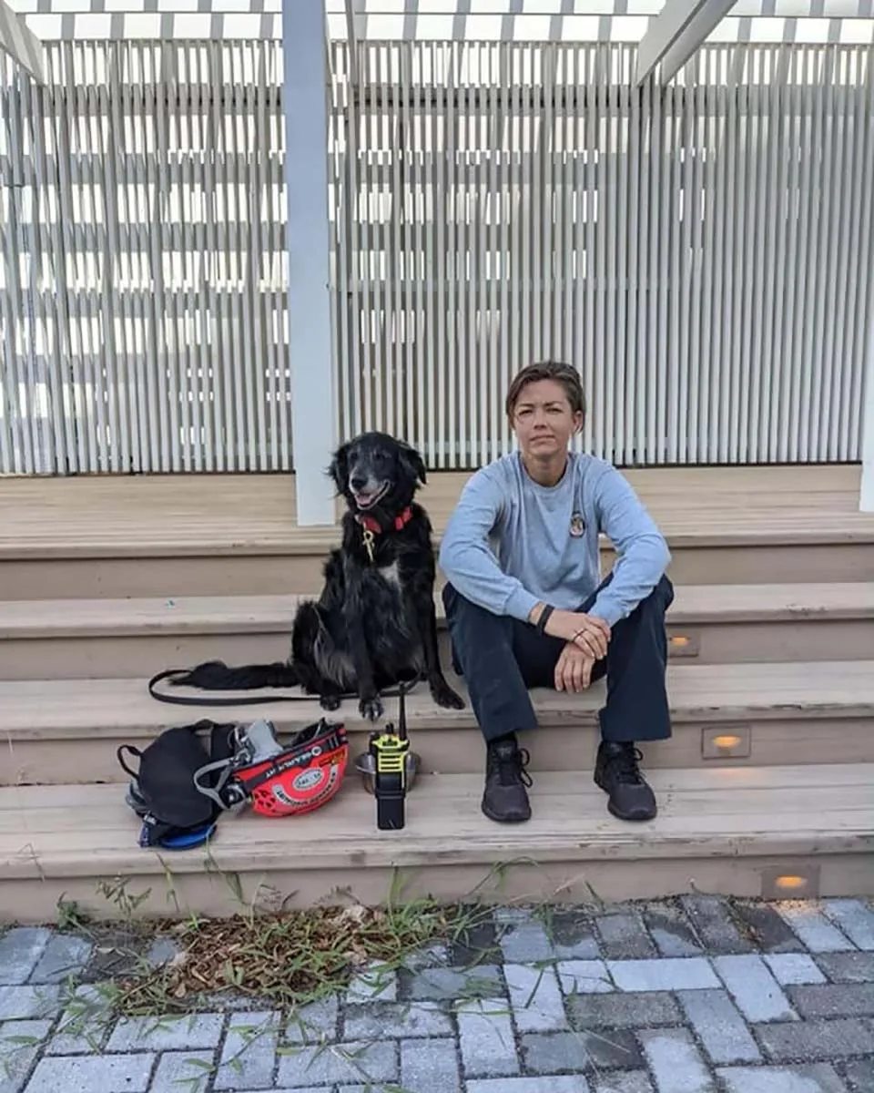 Bombera y su perro caminan entre los restos de un condominio colapsado