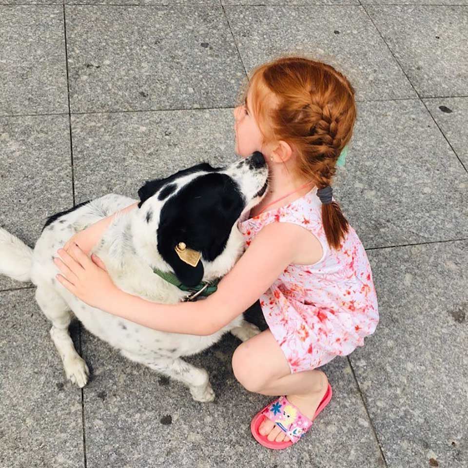 Niña abraza a perro