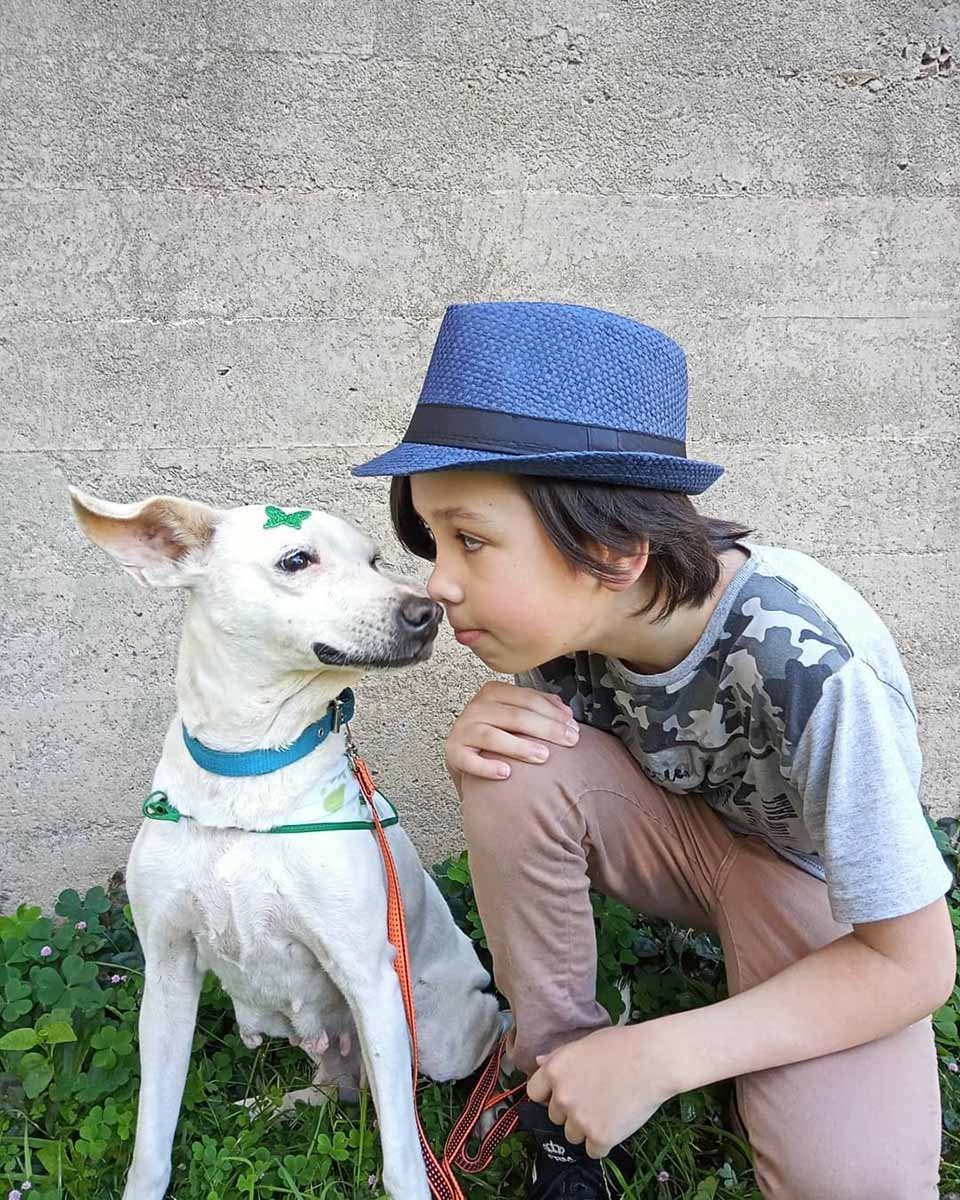 Niño posa junto a perrito sin hogar