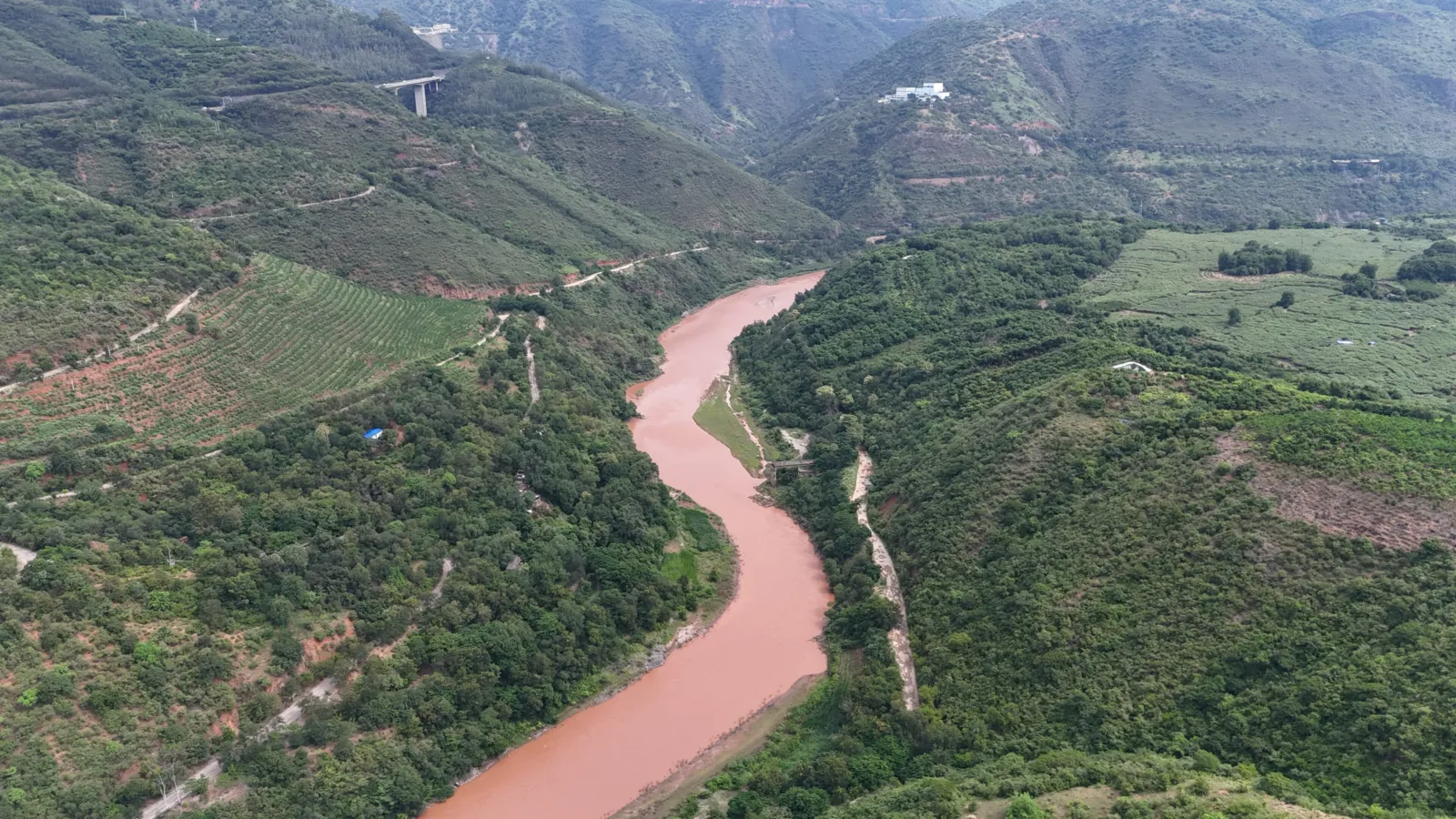Vista aérea del río Yuanjiang, de agua rojiza, serpenteando entre montes verdes